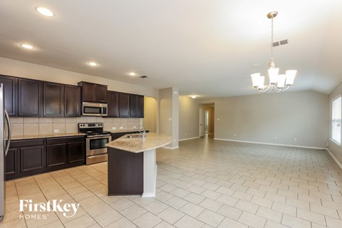 A kitchen with dark wood cabinets and a white island.