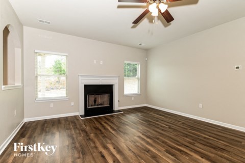 a living room with a fireplace and a ceiling fan