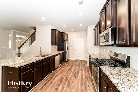a kitchen with granite counter tops and wood floors