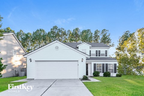 a white house with a garage door and a lawn