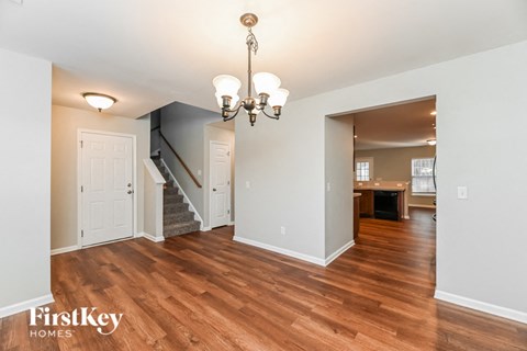a renovated living room and dining room with wood flooring