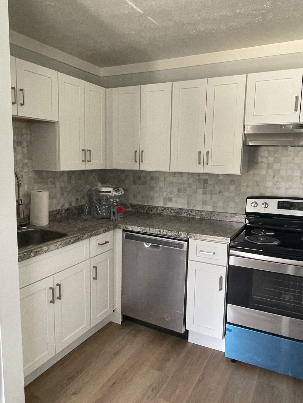 a kitchen with white cabinets and stainless steel appliances