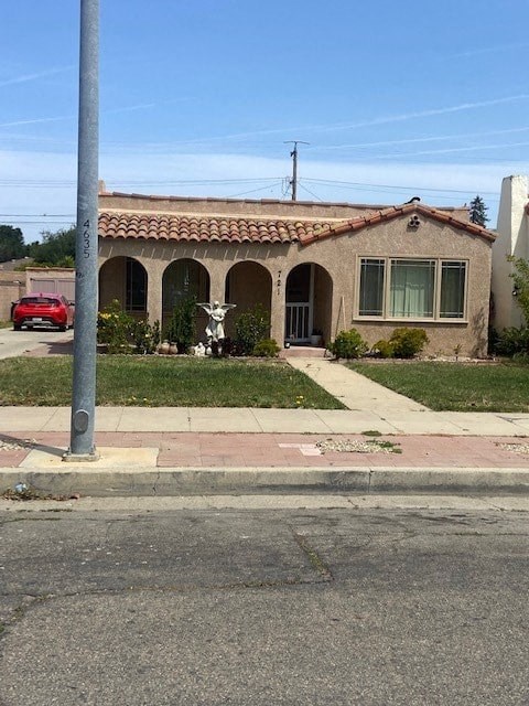 A red car is parked in front of a house.
