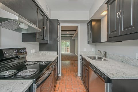 a kitchen with black cabinets and white counter tops and a sink