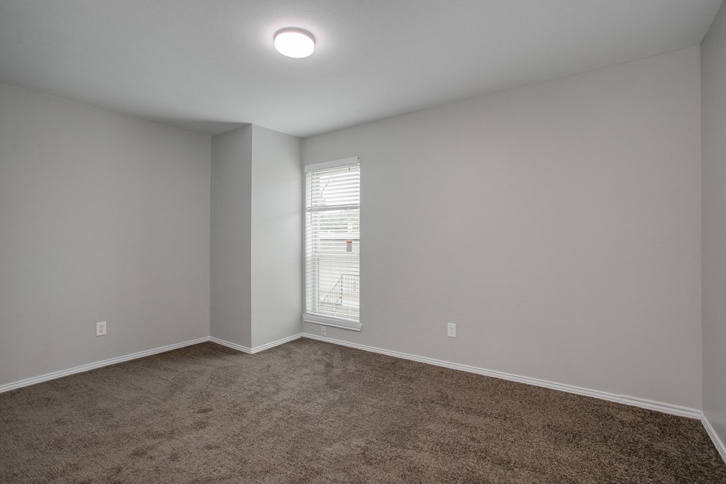 an empty room with carpet and a window
