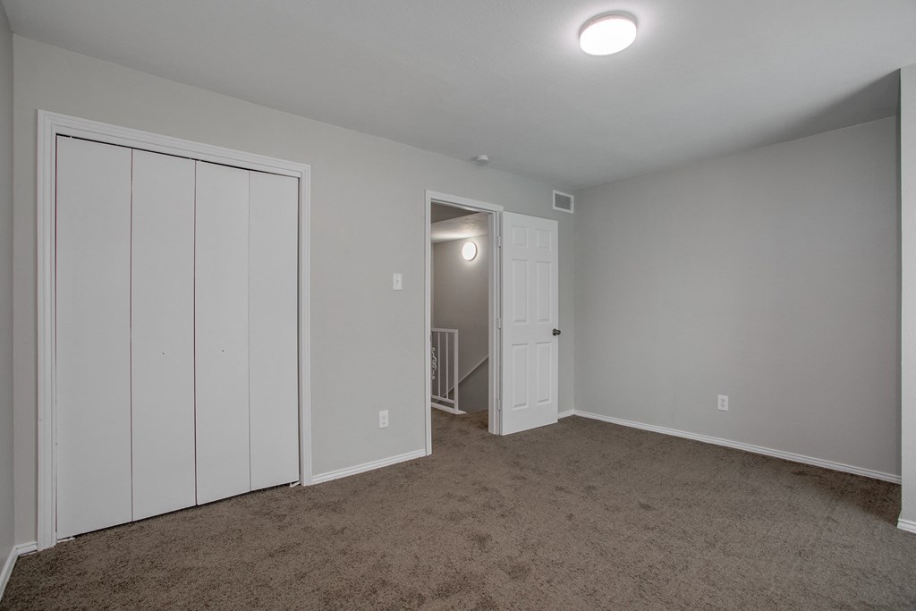 a bedroom with a closet and a door to a hallway