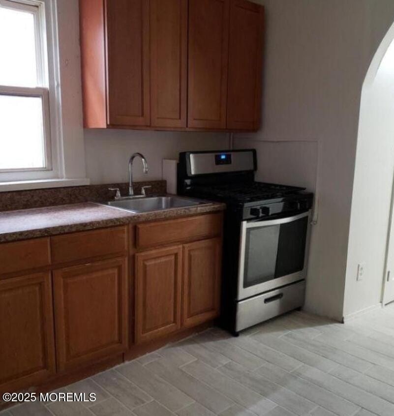 A kitchen with wooden cabinets and a black stove top oven.