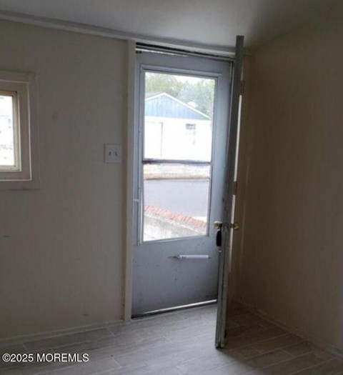 A room with a door leading to a balcony.