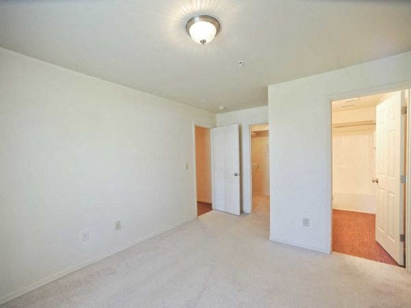 an empty living room with white walls and a door way