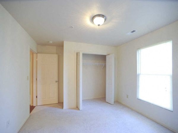 an empty living room with a door to a closet