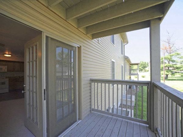 a porch with a sliding glass door and a deck