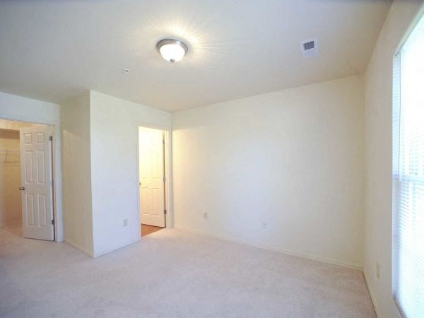 an empty living room with white walls and a door
