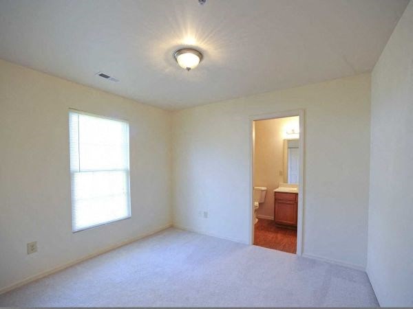 an empty living room with a white floor and a window