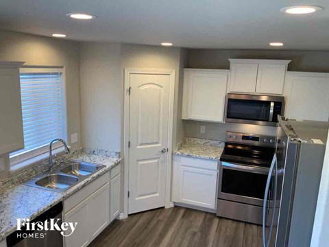 A kitchen with white cabinets and a stainless steel refrigerator.