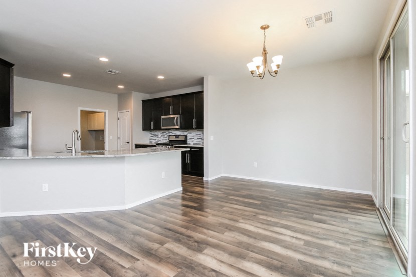 the living room and kitchen of a new home with wood flooring
