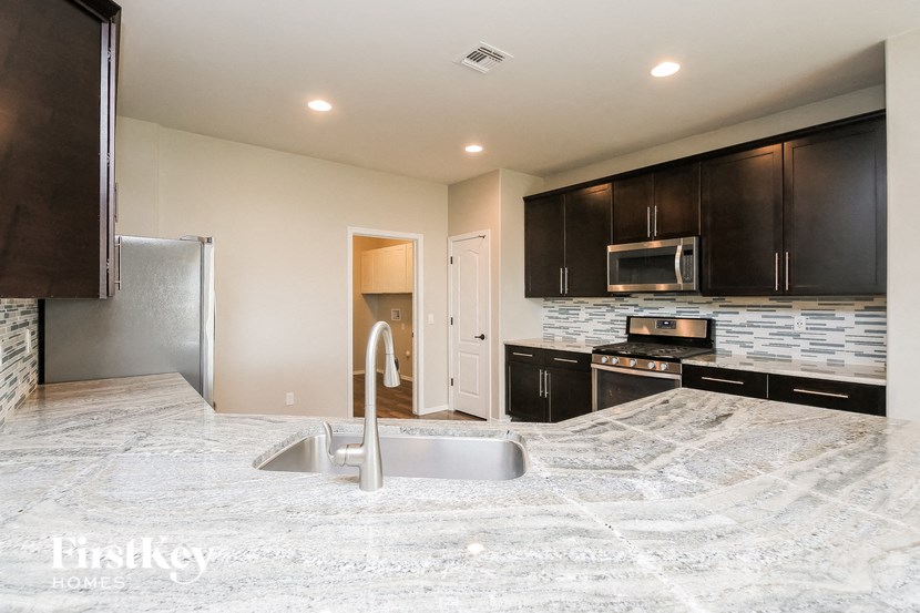 a kitchen with black cabinets and white countertops and a sink
