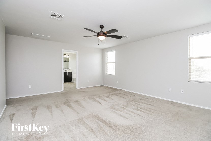a clean and empty living room with a ceiling fan