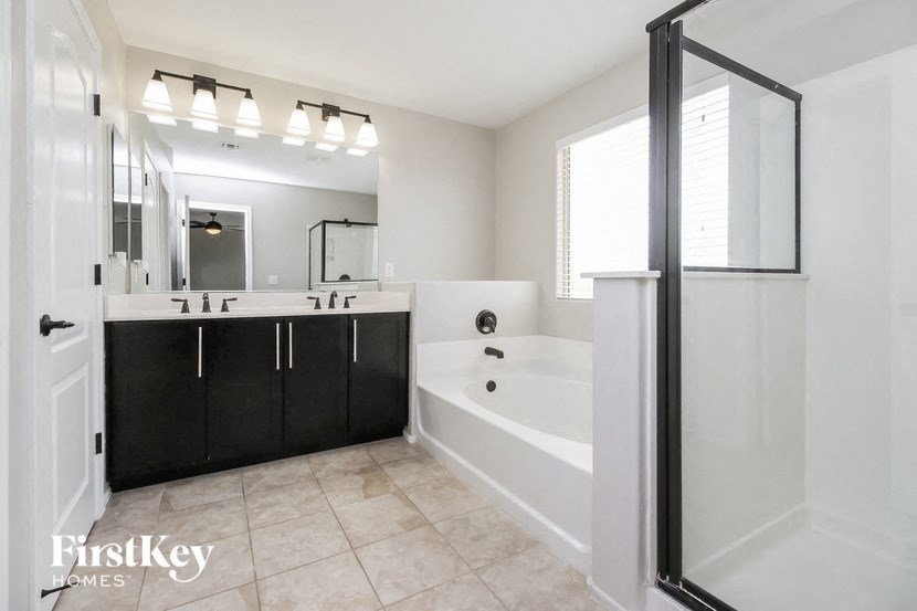 a black and white bathroom with a tub and a shower