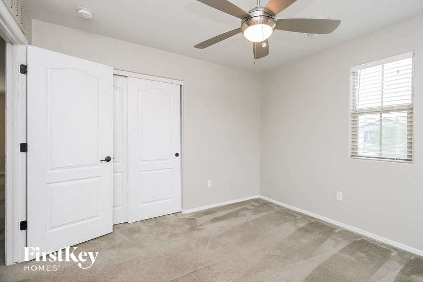 a bedroom with white doors and a ceiling fan