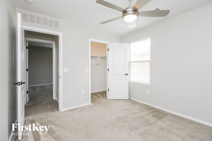 a bedroom with a ceiling fan and a door to a closet