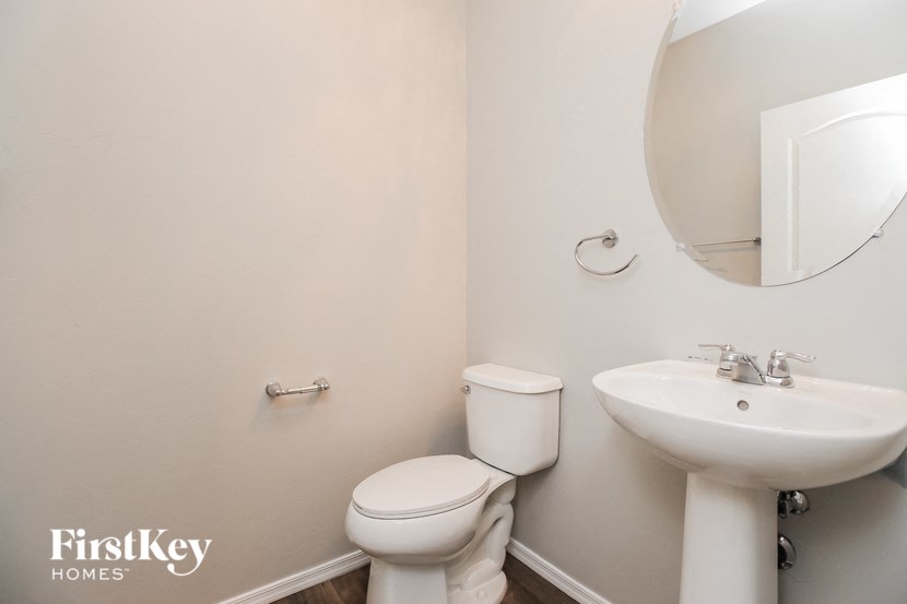a white bathroom with a sink toilet and mirror