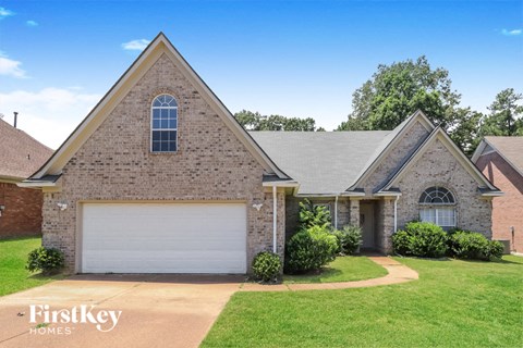 a brick house with a white garage door and a lawn