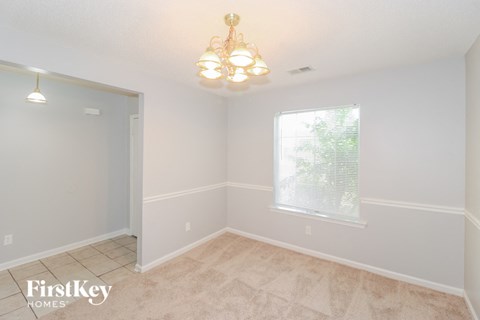 a dining room with a window and a chandelier