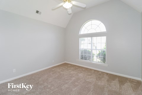 a bedroom with a ceiling fan and a window