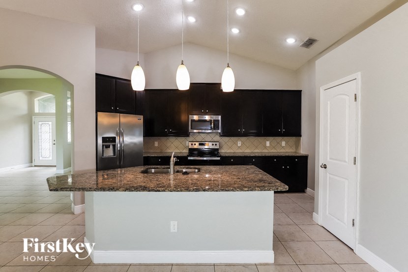 a kitchen with black cabinets and a granite counter top