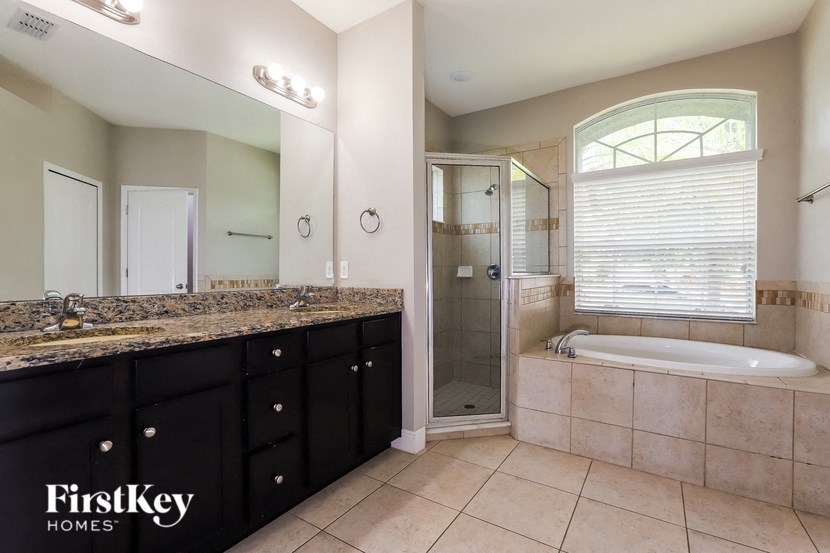 a bathroom with a large tub and a sink and a mirror