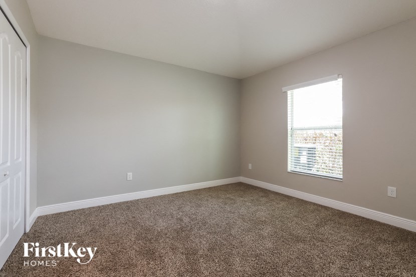 an empty room with carpet and a window