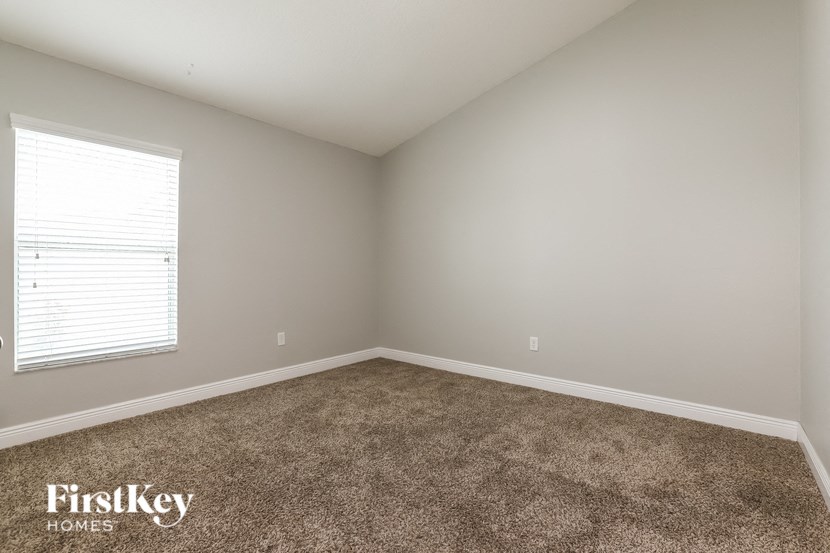 an empty room with carpet and a window