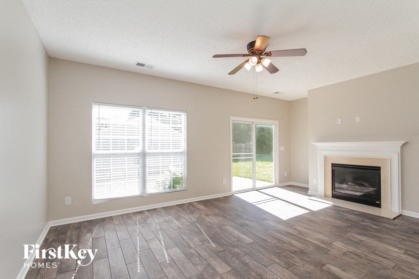 a living room with a ceiling fan and a fireplace