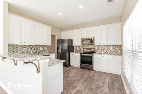 a kitchen with white cabinets and stainless steel appliances