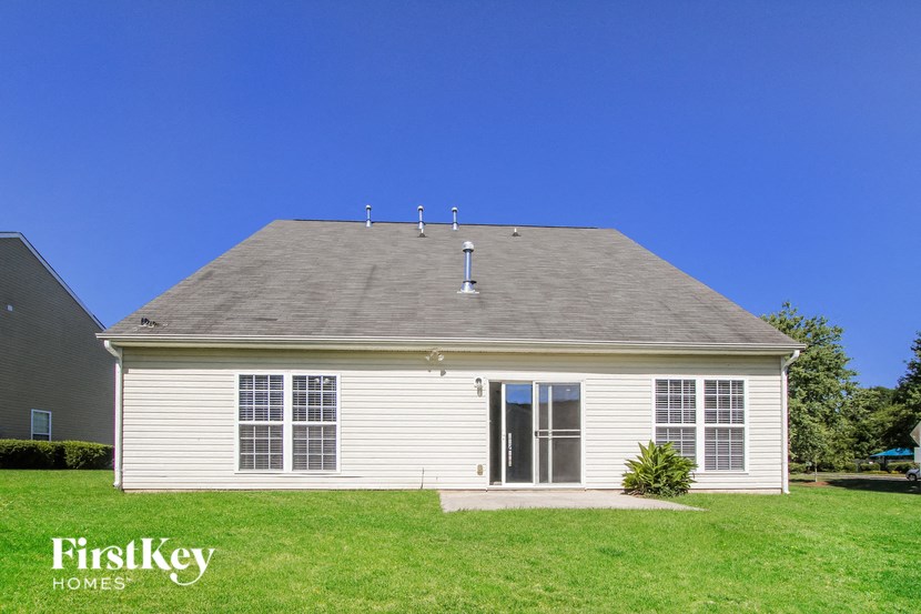 a white house with a gray roof on a green lawn