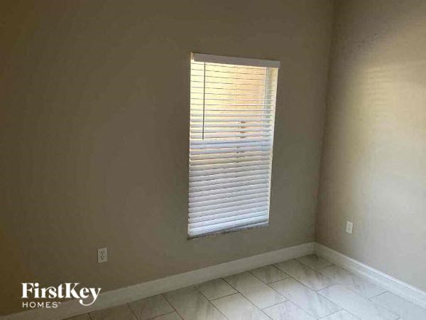 an empty room with a window and a tiled floor