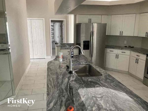 a kitchen with a sink and a stainless steel refrigerator