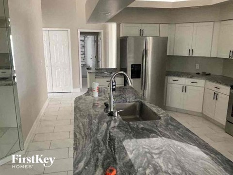 a kitchen with a sink and a stainless steel refrigerator