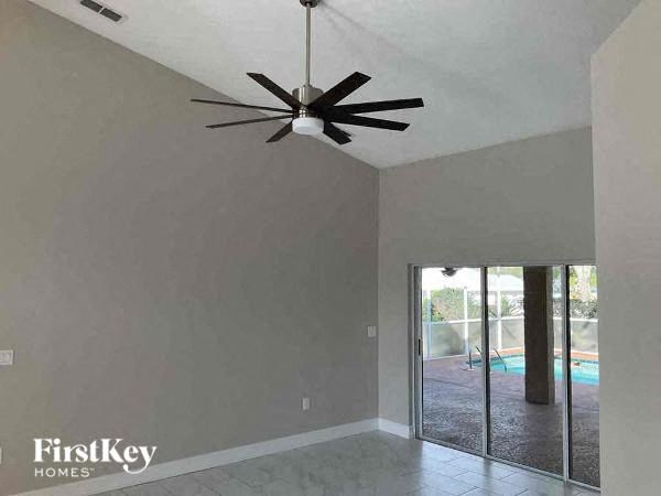 a living room with a ceiling fan and a sliding glass door