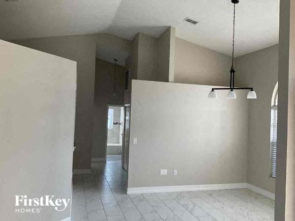 an empty living room with white walls and lights