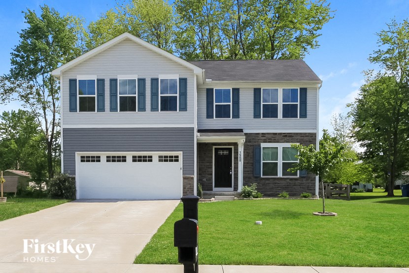 a suburban house with a green lawn and a white garage door