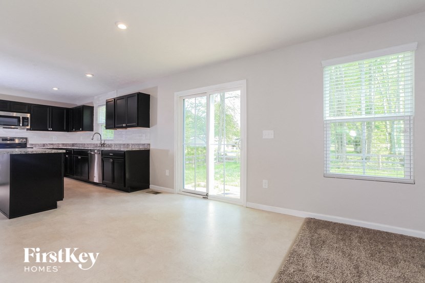 a kitchen with black cabinets and a door to the yard