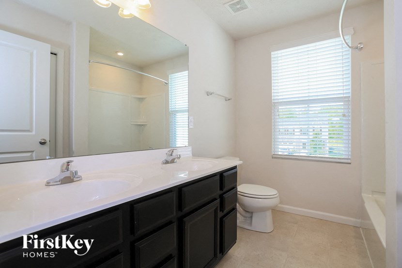 a bathroom with a large mirror and a sink and a toilet