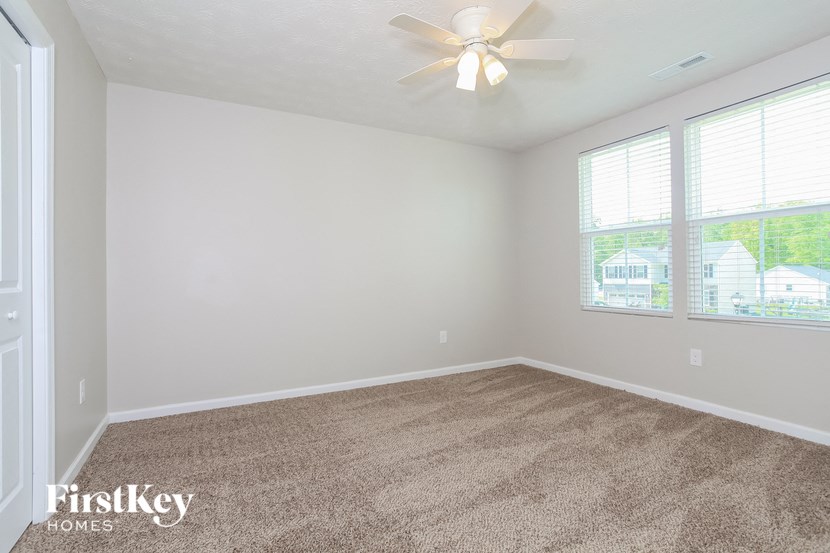 the living room of an empty house with a ceiling fan