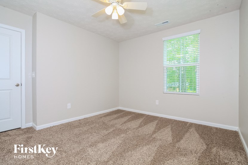 a bedroom with carpet and a ceiling fan