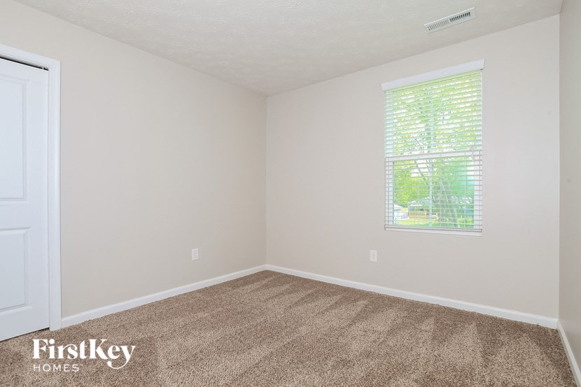 a bedroom with a carpeted floor and a window