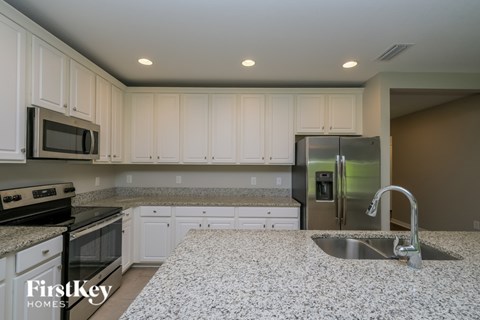 A kitchen with granite countertops and a stainless steel sink.