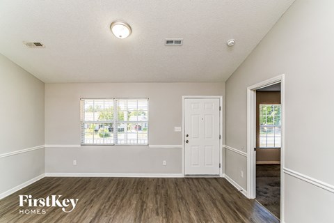 A room with a wooden floor and a white door.