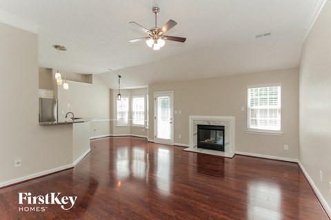A spacious living room with wood floors and a fireplace.
