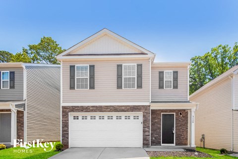 a tan house with a white garage door